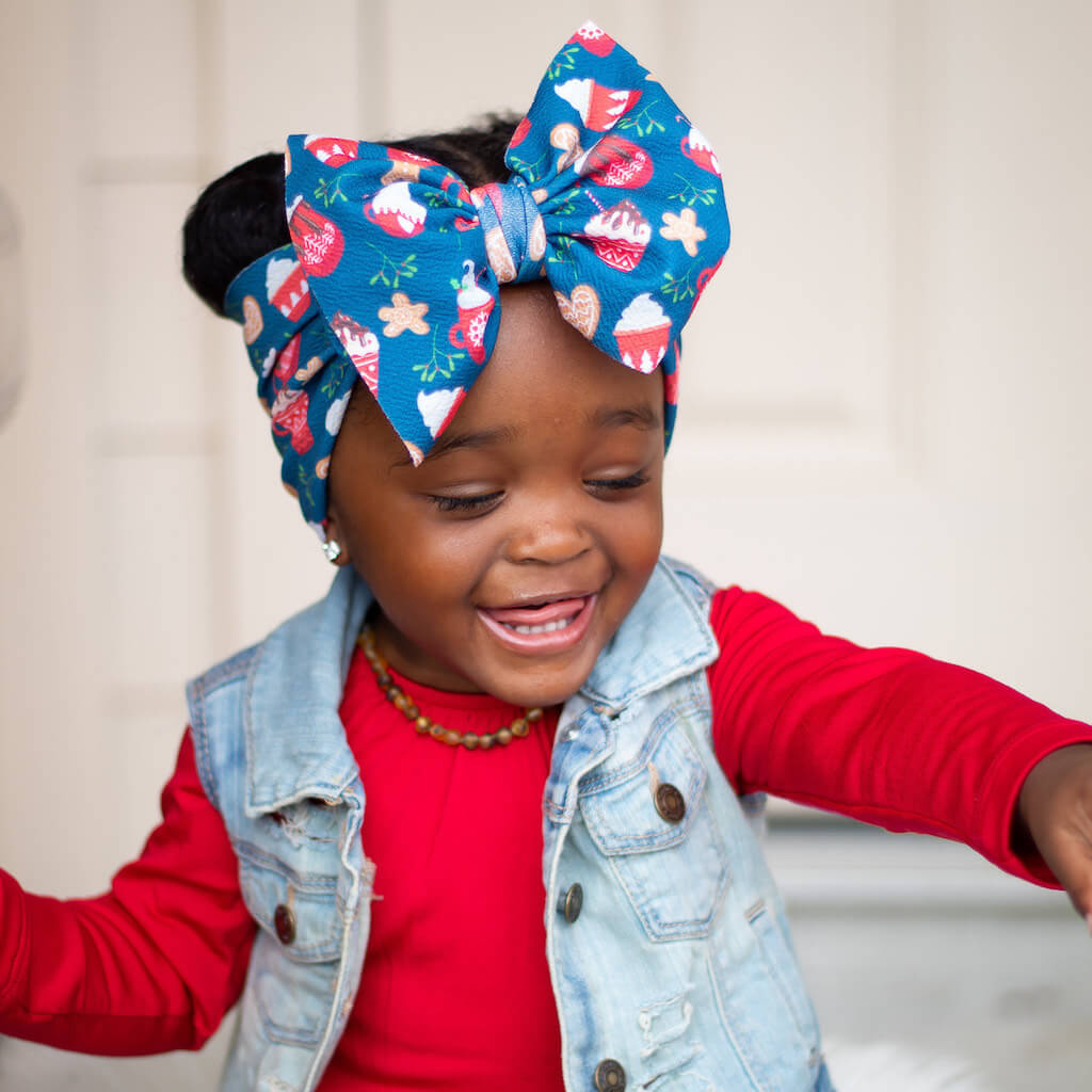 Smiling African American Baby Girl with Head Bow and Raw Baltic Amber Teething Necklace in Green Color from Amber Guru